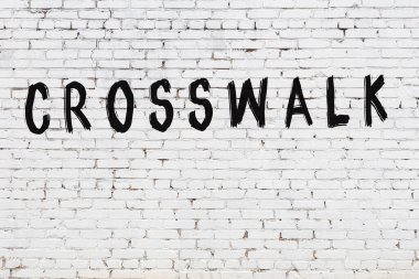 Üzerinde siyah boyalı yaya geçidi olan beyaz bir duvar.