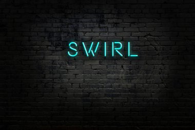 Üzerinde yazı olan neon levhası tuğla duvara vuruyor.