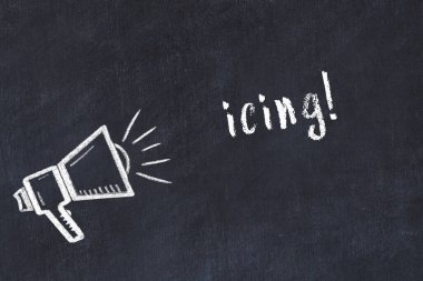 Tebeşir hoparlörü ve siyah karatahtaya yazılan krema