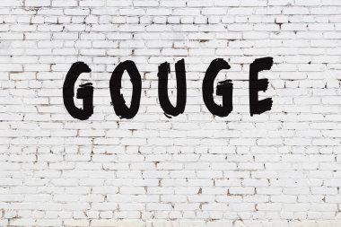 Beyaz tuğla duvara yazı kazınmış.