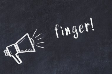 Tebeşir hoparlörü ve yazı parmağı siyah karatahtanın üzerinde.