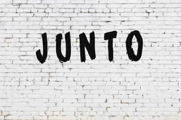 Word junto painted on white brick wall — Stock Photo, Image