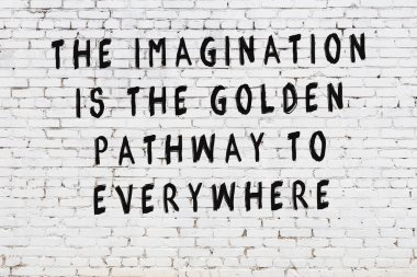 Beyaz tuğla duvar arkaplanına siyah düşünceli bir yazı.