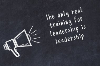 Tebeşir hoparlörü ve siyah masada akıllıca bir alıntı.