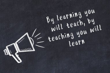 Tebeşir hoparlörü ve siyah masada akıllıca bir alıntı.