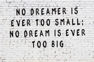 Beyaz tuğla duvar arkaplanına siyah düşünceli bir yazı.