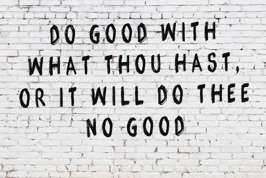 White brick wall with painted black inscription of wise quote