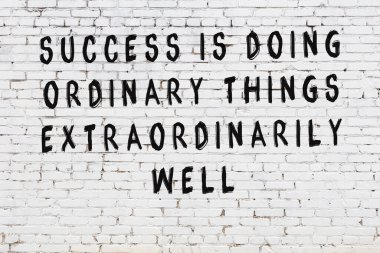 Bilgece alıntıların yazılı olduğu siyah boyanmış beyaz tuğla duvar