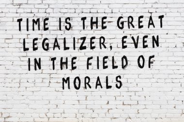 Beyaz tuğla duvara zekice alıntılar yazılı siyah bir yazı.