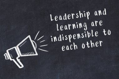 Tebeşir hoparlörü ve siyah masada akıllıca bir alıntı.