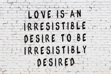 Bilgece alıntıların yazılı olduğu siyah boyanmış beyaz tuğla duvar