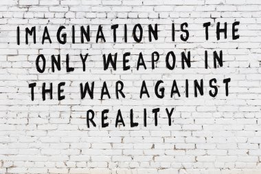 Beyaz tuğla duvar arkaplanına siyah düşünceli bir yazı.