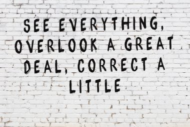 Bilgece alıntıların yazılı olduğu siyah boyanmış beyaz tuğla duvar