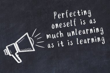 Tebeşir hoparlörü ve siyah masada akıllıca bir alıntı.