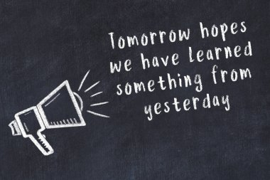 Tebeşir hoparlörü ve siyah masada akıllıca bir alıntı.