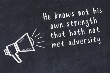 Tebeşir hoparlörü ve siyah masada akıllıca bir alıntı.