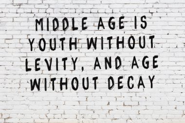 Beyaz tuğla duvar arkaplanına siyah düşünceli bir yazı.