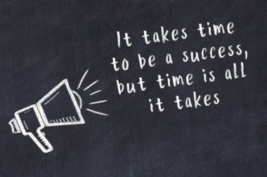 Tebeşir hoparlörü ve siyah masada akıllıca bir alıntı.