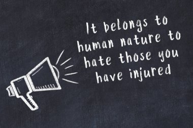 Tebeşir hoparlörü ve siyah masada akıllıca bir alıntı.