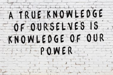 Bilgece alıntıların yazılı olduğu siyah boyanmış beyaz tuğla duvar