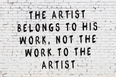 Beyaz tuğla duvara zekice alıntılar yazılı siyah bir yazı.