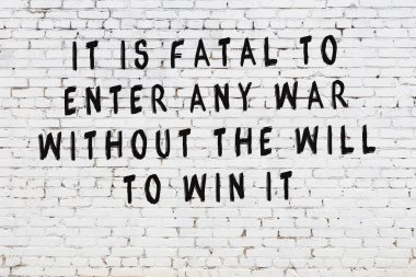 Bilgece alıntıların yazılı olduğu siyah boyanmış beyaz tuğla duvar