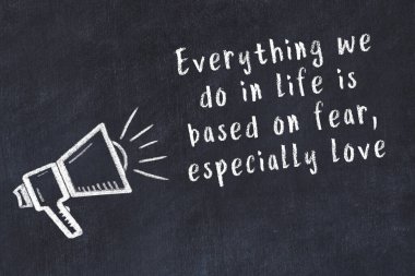 Tebeşir hoparlörü ve siyah masada akıllıca bir alıntı.