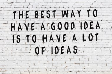 Beyaz tuğla duvar arkaplanına siyah düşünceli bir yazı.