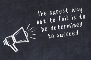 Tebeşir hoparlörü ve siyah masada akıllıca bir alıntı.