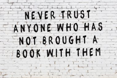 Beyaz tuğla duvar arkaplanına siyah düşünceli bir yazı.