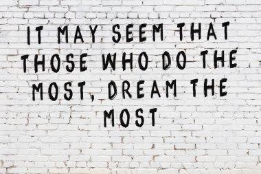 Bilgece alıntıların yazılı olduğu siyah boyanmış beyaz tuğla duvar