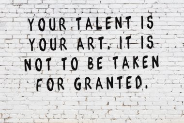 Beyaz tuğla duvar arkaplanına siyah düşünceli bir yazı.