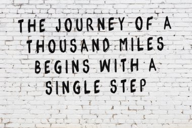 Bilgece alıntıların yazılı olduğu siyah boyanmış beyaz tuğla duvar