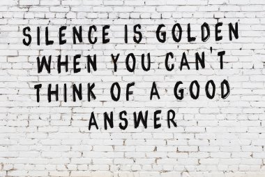 Beyaz tuğla duvara zekice alıntılar yazılı siyah bir yazı.