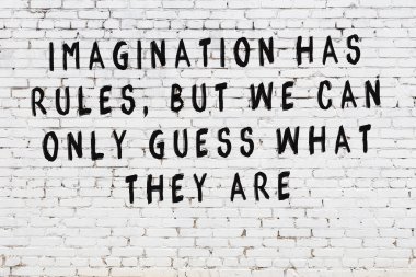 Beyaz tuğla duvar arkaplanına siyah düşünceli bir yazı.