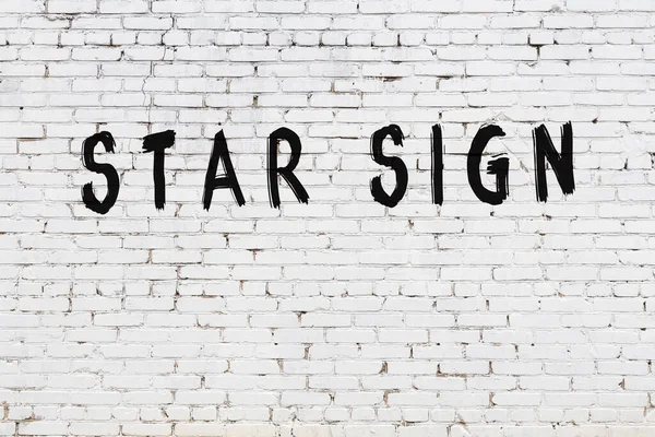 Parede branca com sinal de estrela de inscrição de tinta preta — Fotografia de Stock