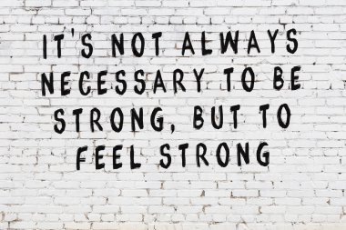 Bilgece alıntıların yazılı olduğu siyah boyanmış beyaz tuğla duvar