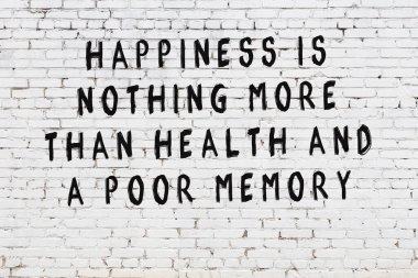 Beyaz tuğla duvar arkaplanına siyah düşünceli bir yazı.