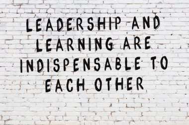 Beyaz tuğla duvar arkaplanına siyah düşünceli bir yazı.