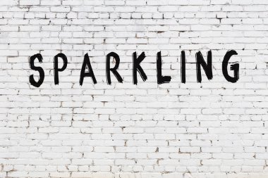 Üzerinde siyah boya yazılı beyaz duvar parlıyor.