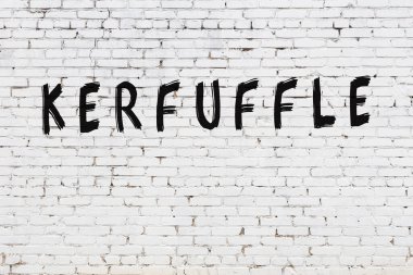 Üzerinde siyah boya yazıtları olan beyaz duvar.