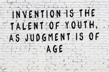 Beyaz tuğla duvar arkaplanına siyah düşünceli bir yazı.