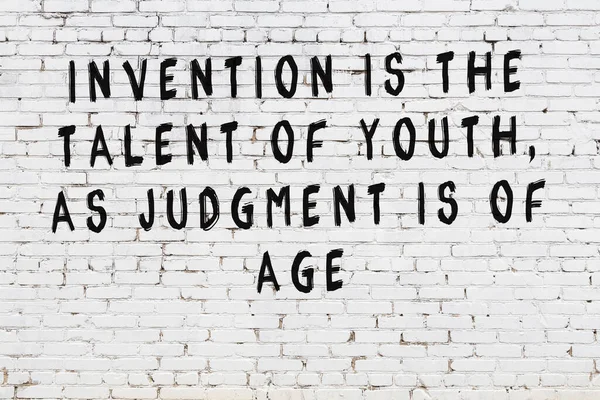 Beyaz tuğla duvar arkaplanına siyah düşünceli bir yazı.