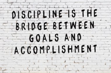 Beyaz tuğla duvar arkaplanına siyah düşünceli bir yazı.