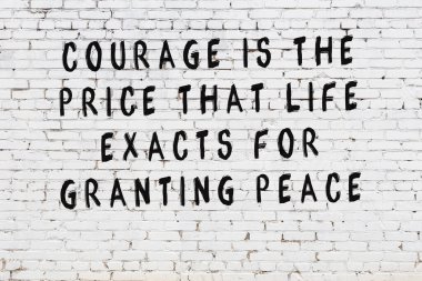 Beyaz tuğla duvar arkaplanına siyah düşünceli bir yazı.