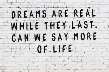 Beyaz tuğla duvar arkaplanına siyah düşünceli bir yazı.