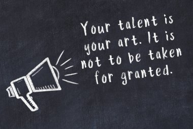 Tebeşir hoparlörü ve siyah masada akıllıca bir alıntı.