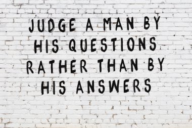 Bilgece alıntıların yazılı olduğu siyah boyanmış beyaz tuğla duvar