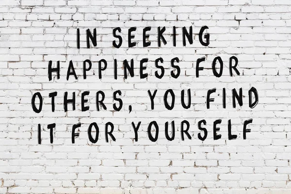 Bilgece alıntıların yazılı olduğu siyah boyanmış beyaz tuğla duvar