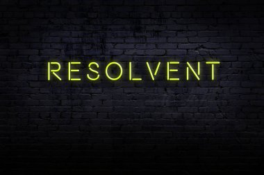 Neon işareti. Kelime, tuğla duvara karşı çözülür. Gece görünümü